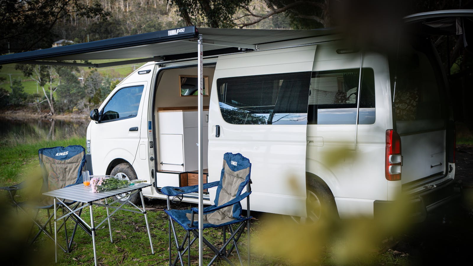 Luxury 2-berth Manali campervan with awning, table and chairs for relaxed Tasmanian outdoor living.