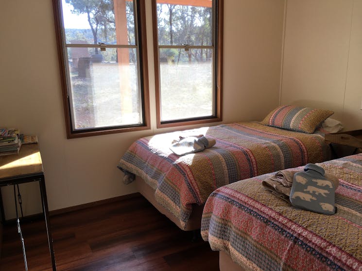 Two king single beds, sidetable, two windows