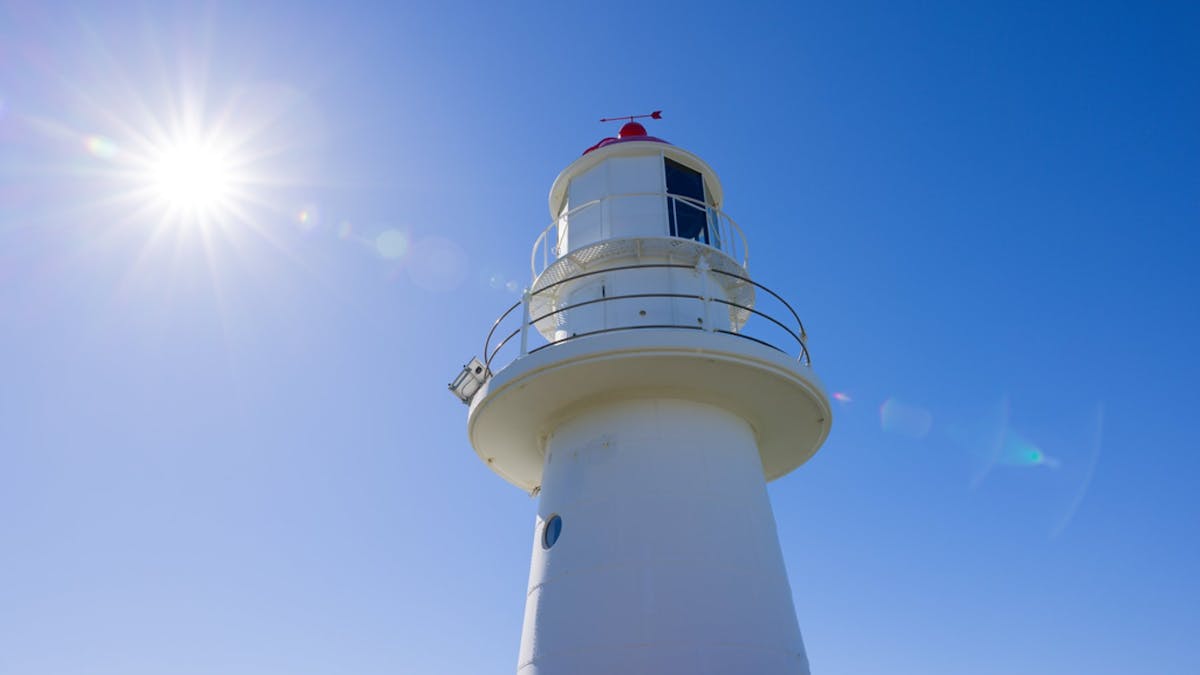 Lighthouse with the sun shining brightly on it