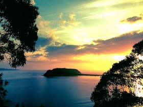 The silouette of Barrenjoey Headland and Palm Beach on Pittwater after a sunrise kayak tour.