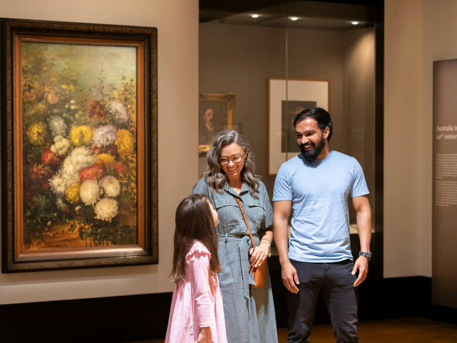 A man, woman and young girl in the Treasures Gallery at the National Library of Australia