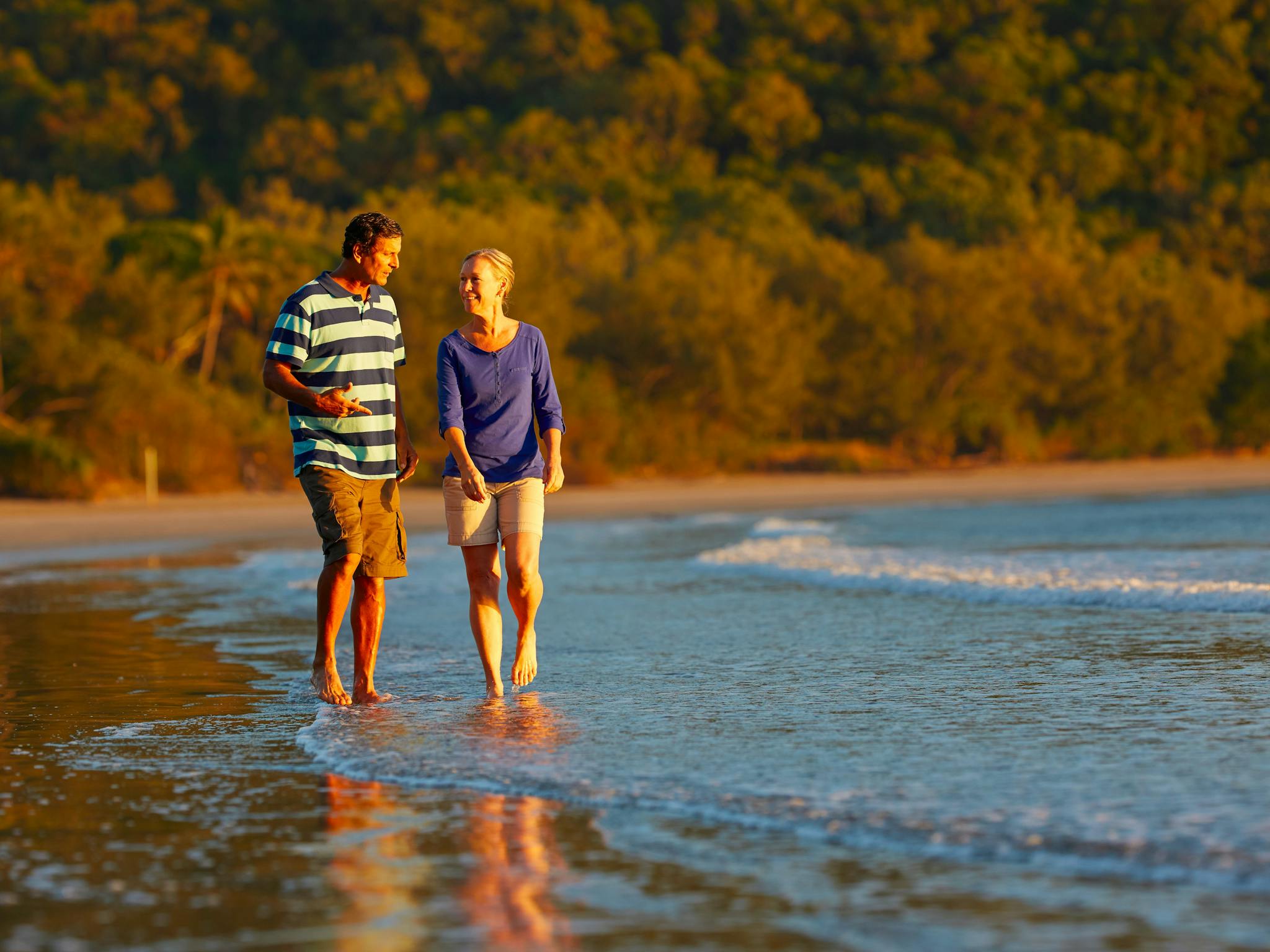 Couple taking a stroll along Cape Hillsborough beac Couple taking a stroll along Cape Hillsborough beac