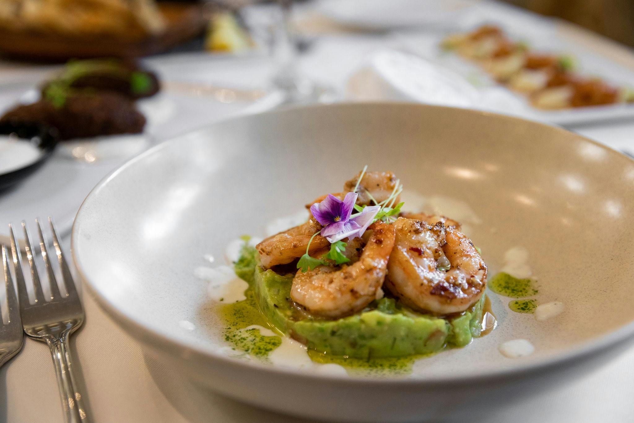 Chilli garlic prawns served on a bed of guacamole with basil aioli