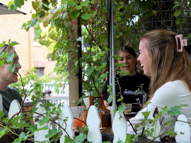 Guests sitting in the leafy courtyard at The Coffee House