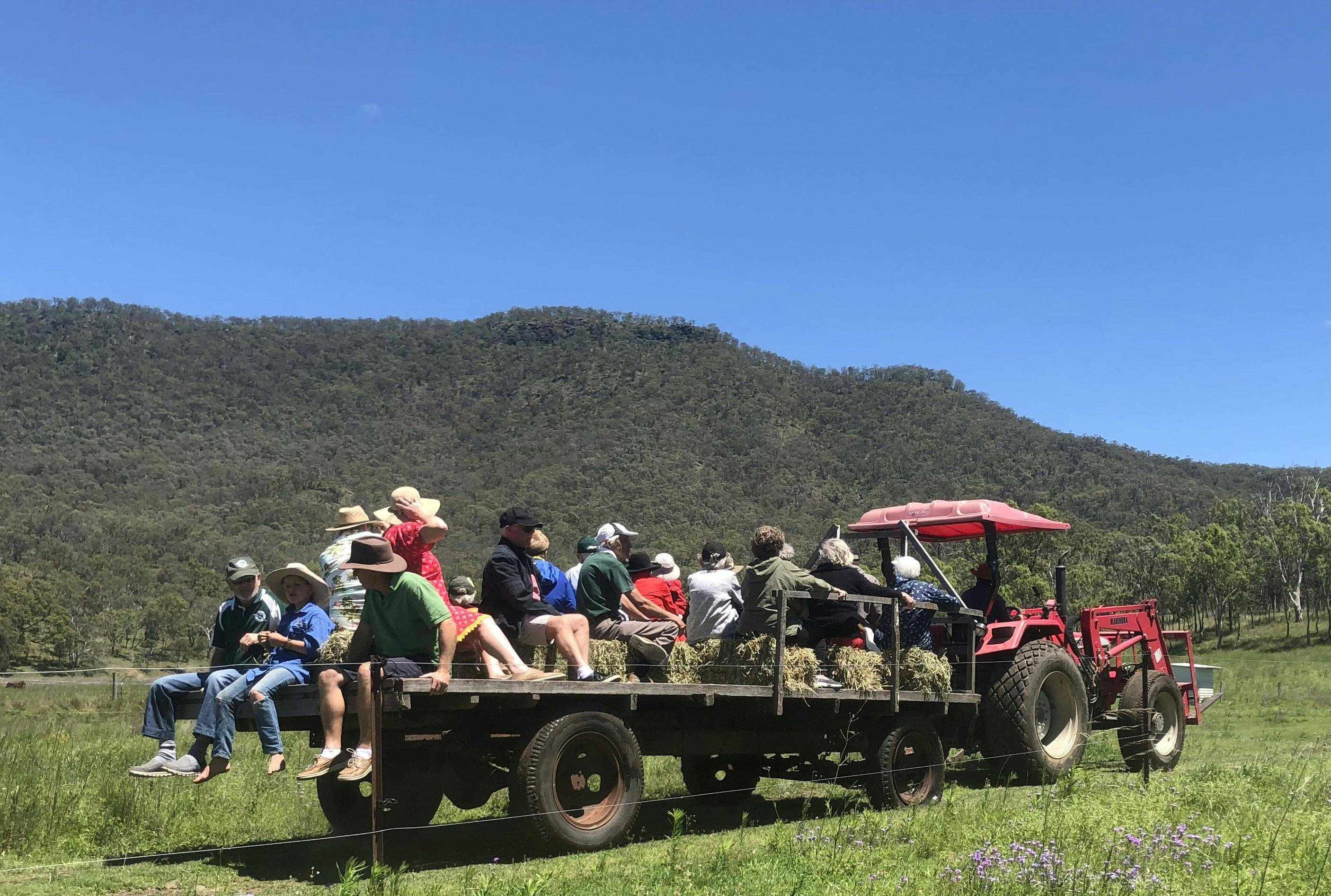 People riding on a haywagon pullled by a tractor