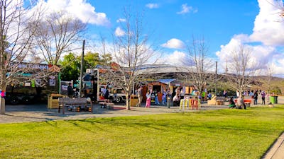 A landscape image shows a row of food vans and vendor stalls with lots of people of all ages