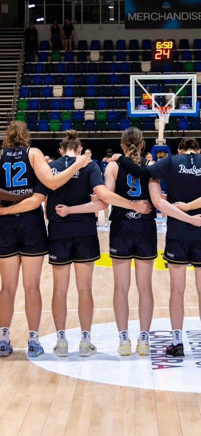 UC Capitals stand in a line after their names are called before the start of a game.