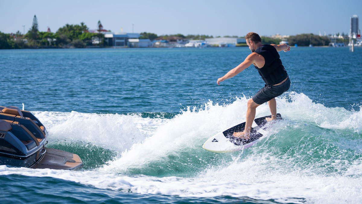 Crystal clear water with a wake surfer enjoying an awesome day behind the boat Crystal clear water with a wake surfer enjoying an awesome day behind the boat