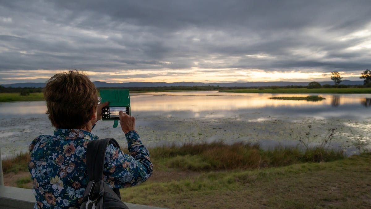 A woman takes a photo of the St Lawrence Wetlands