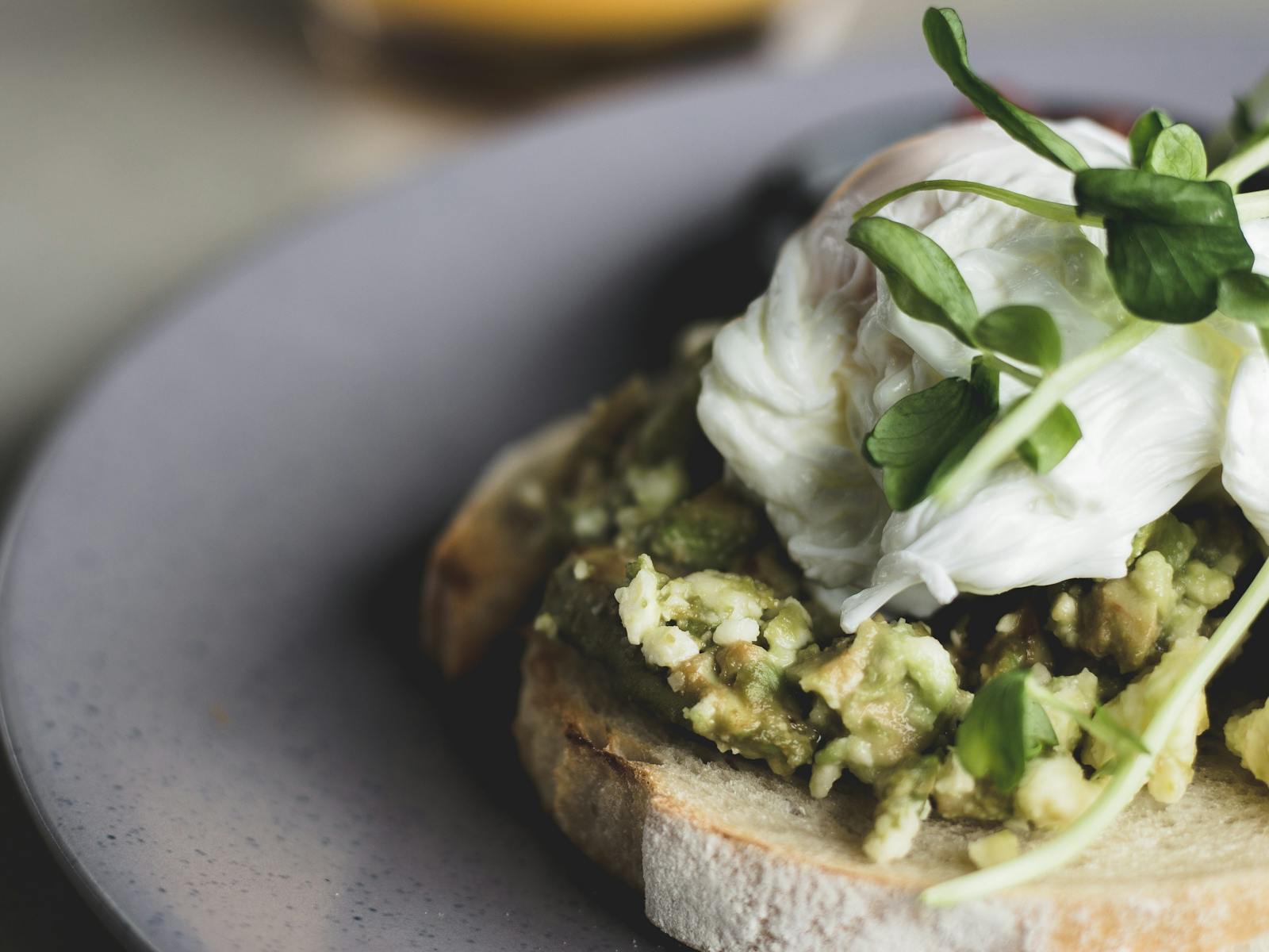 Close up image of poached eggs on smashed avocado, on sourdough toast.