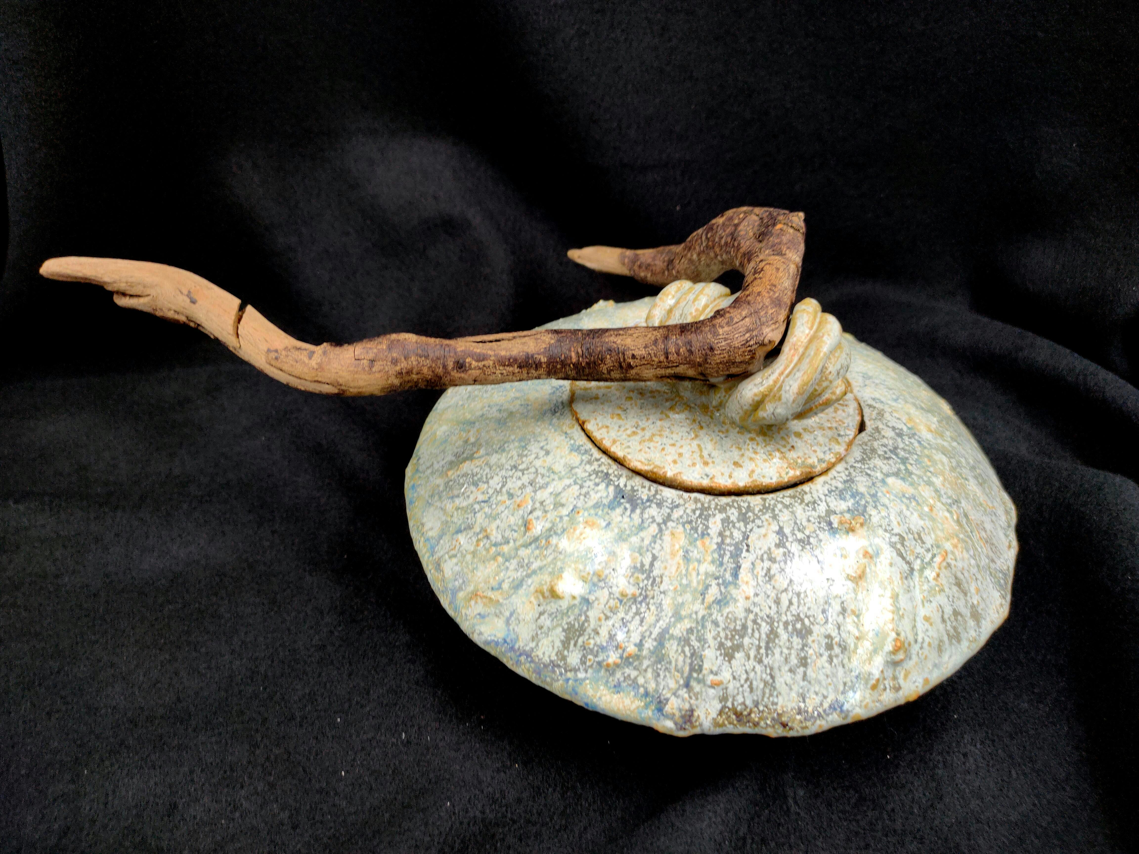 An angled top view of the Disc Urn, highlighting the reactive glaze textures and the natural sculptu