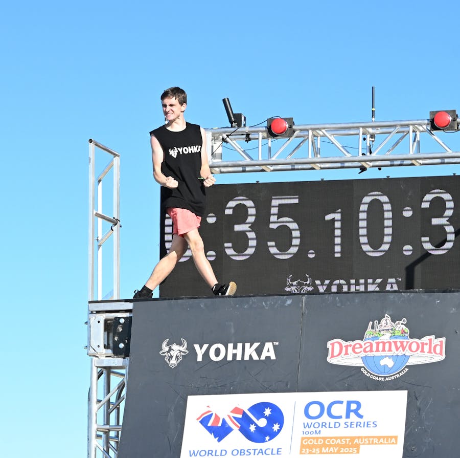 Male athlete celebrates on top of a wall
