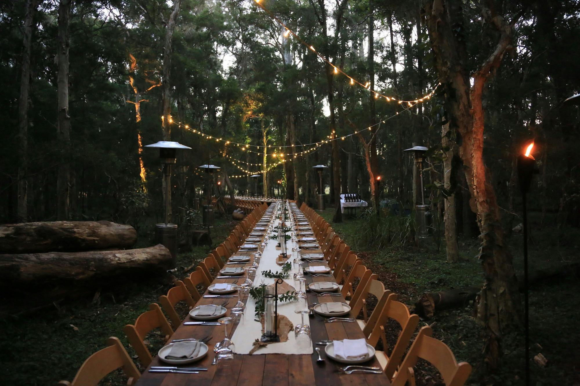 Communal long table under the stars amongst the paperbark trees to celebrate 25 years of Paperbark