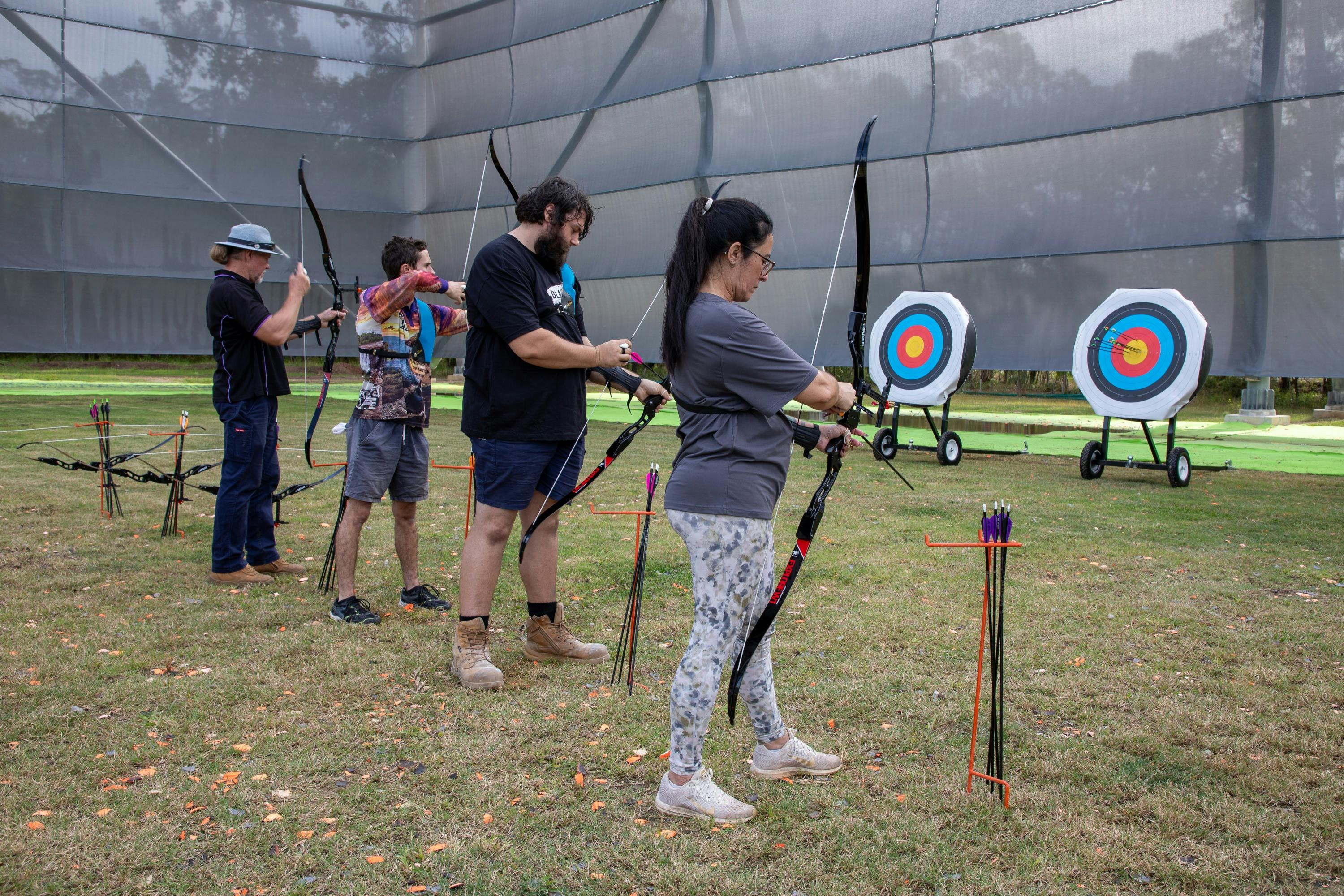 Group of participants having fun shooting a bow