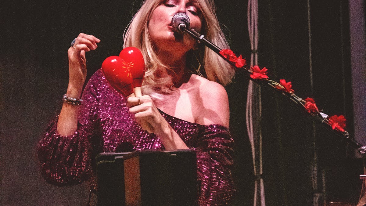 Blonde woman singing with maracas