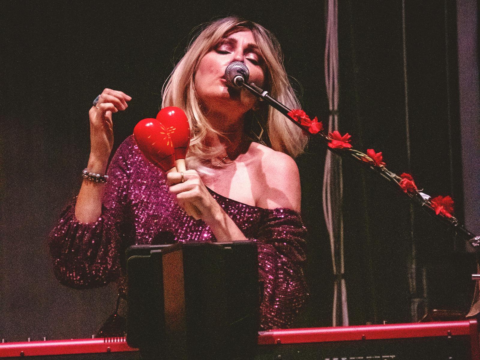 Blonde woman singing with maracas
