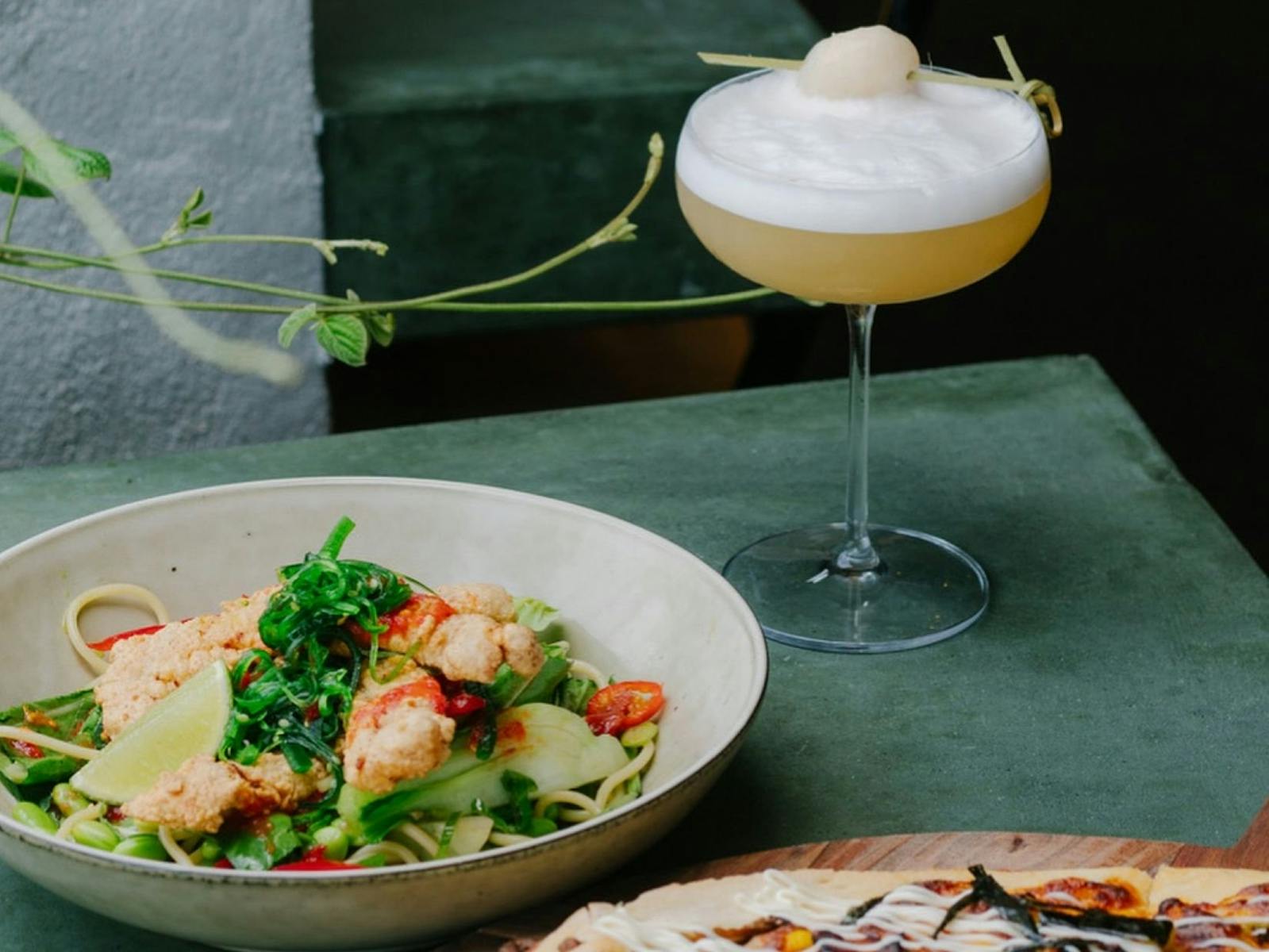 Image of a cocktail with a salad on a table