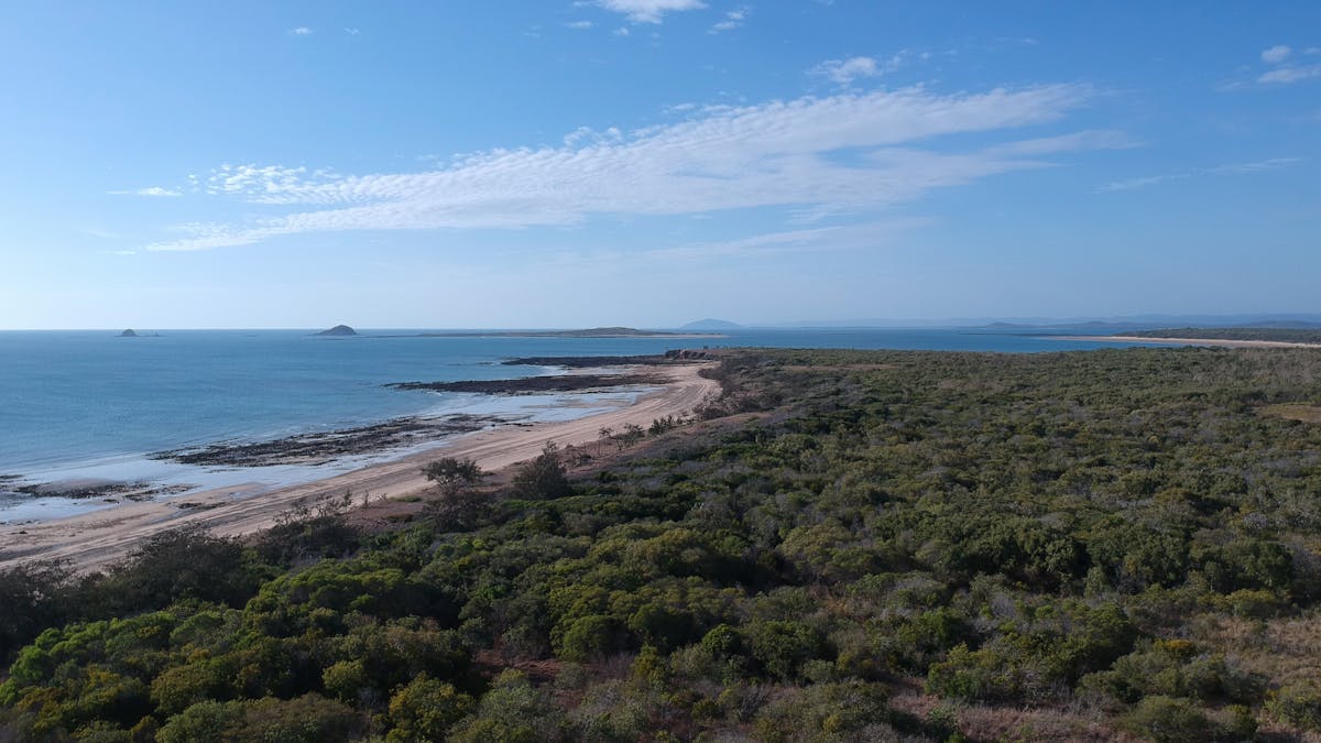Shot of the Isaac Coast line with sand, blue water and trees
