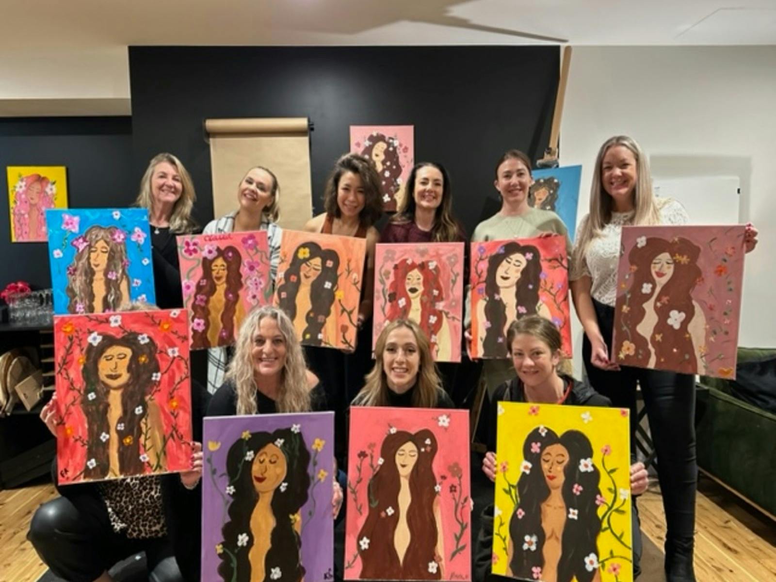 People holding up their finished paintings