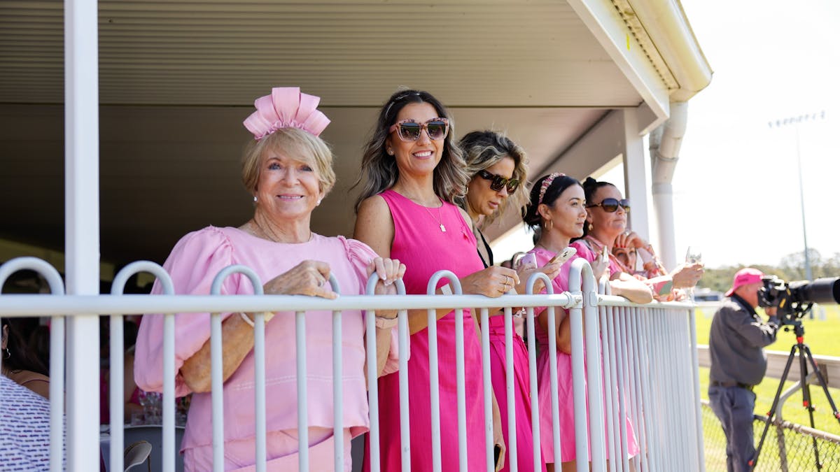Ladies smiling in the Champagne Garden watching the races