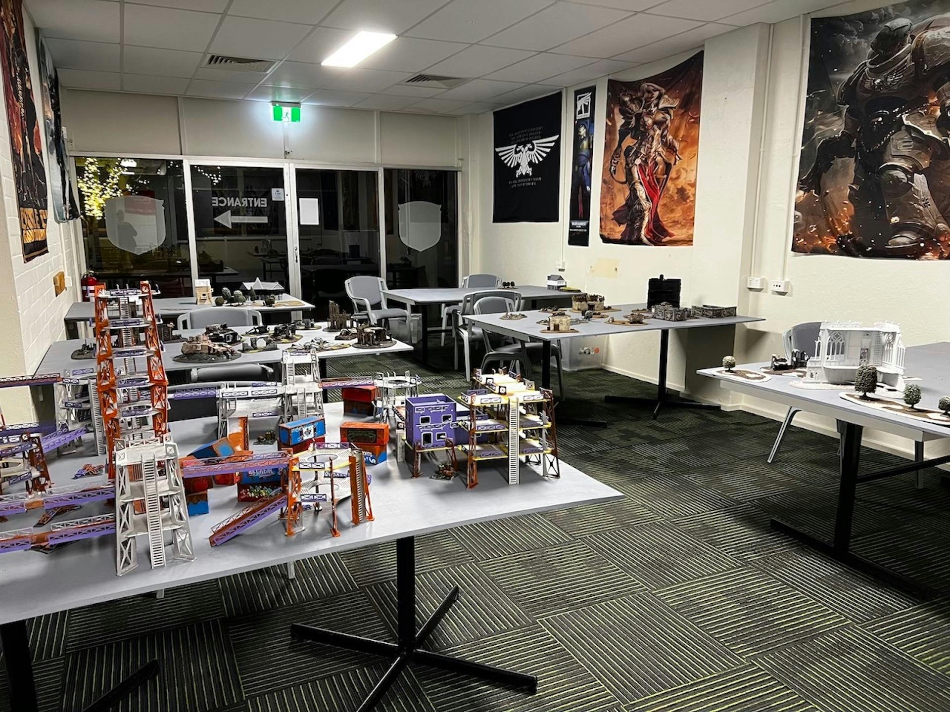 Warhammer tables with terrain and miniatures, ready for gaming sessions.