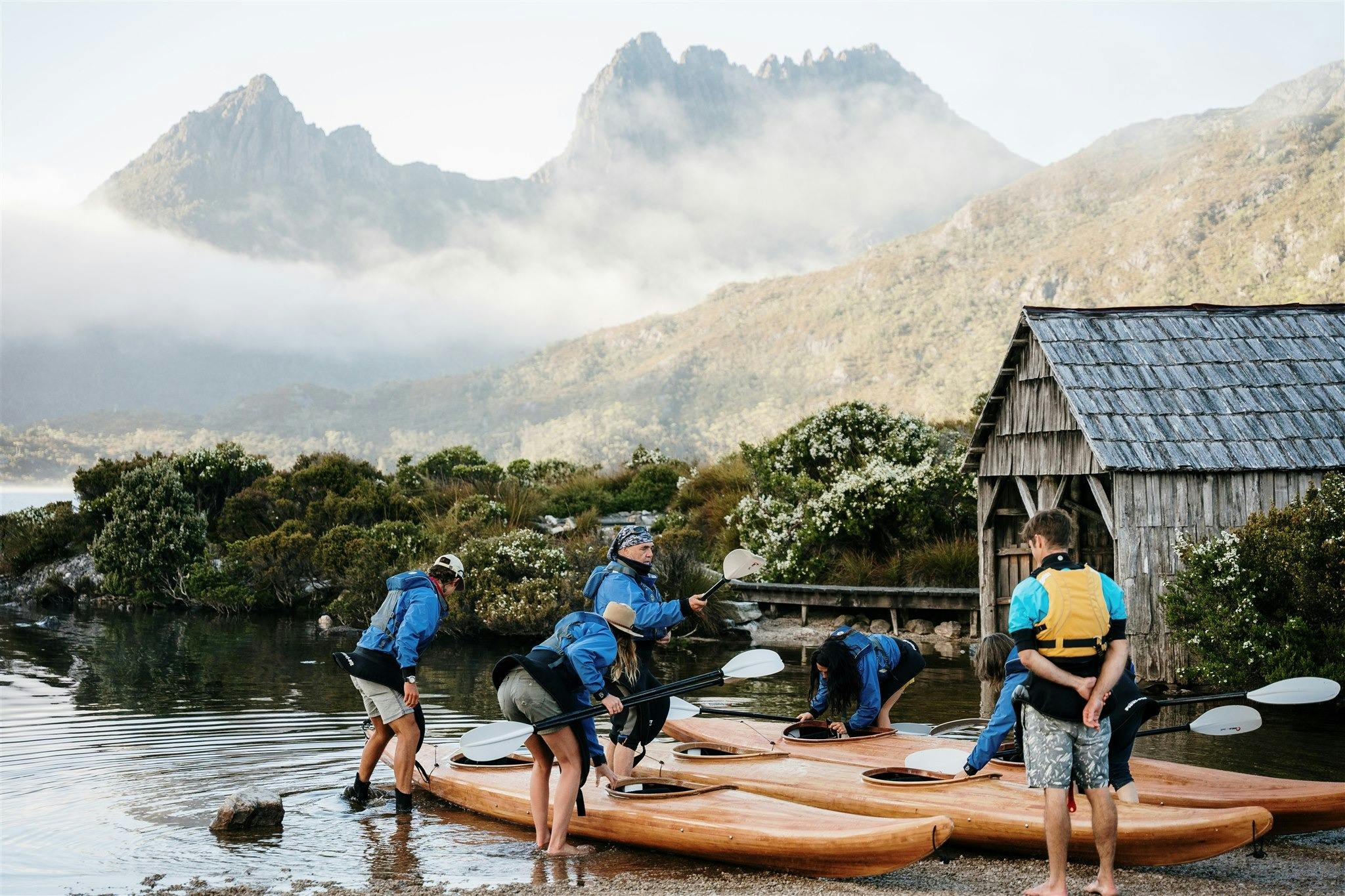 four kayaks on a beach next to the boat shed at Cradle Mountain
