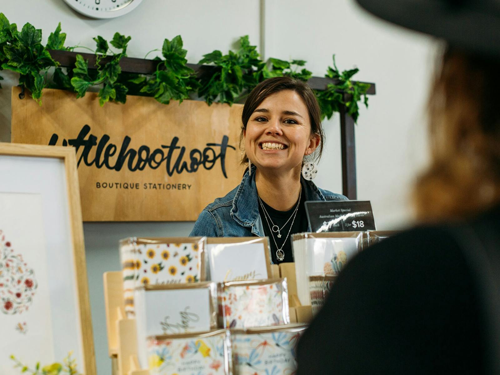 Stallholder smiling at camera from their indoor stall.