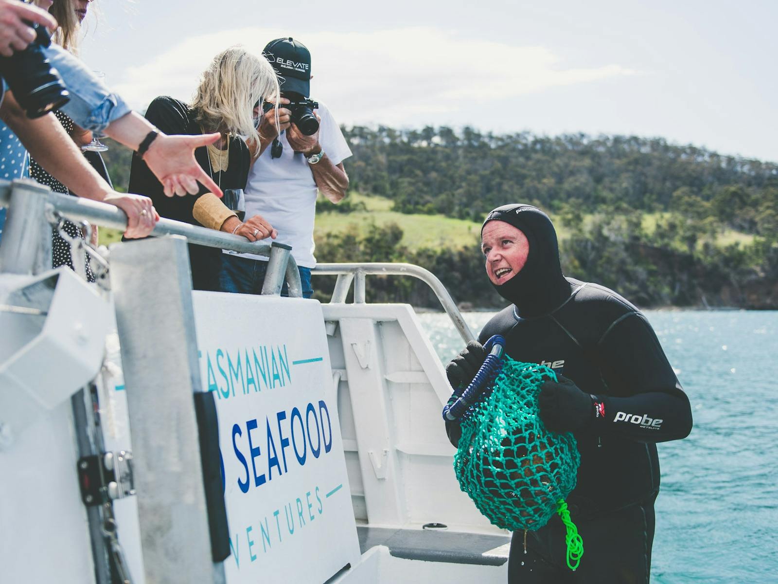 Diver holding urchin and periwinkle catch fresh from the ocean