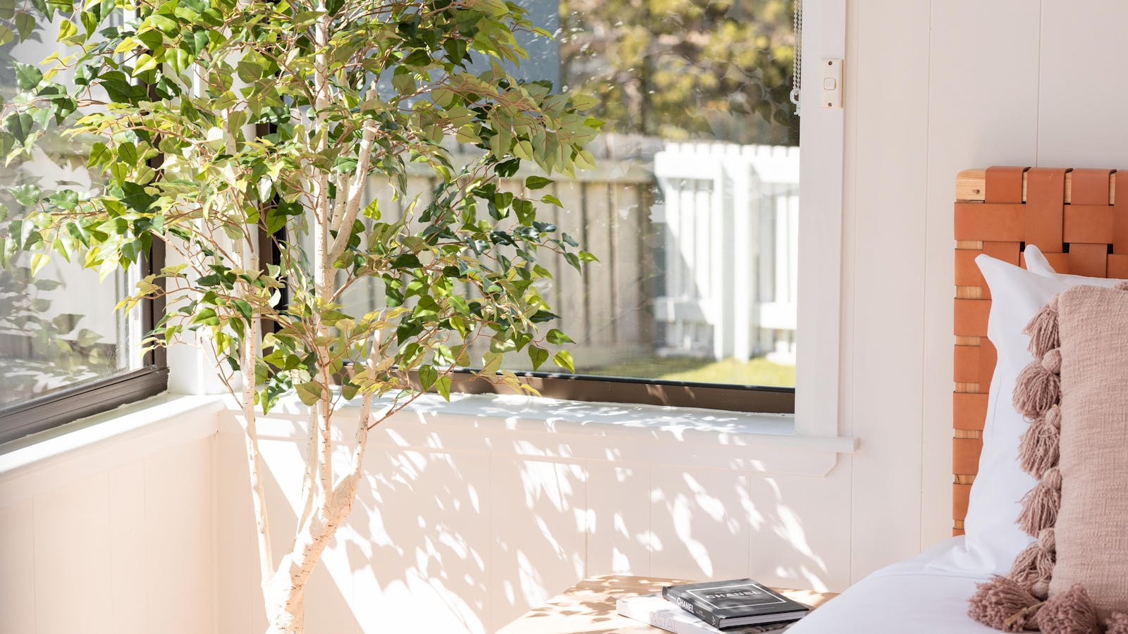Sunny bedroom corner with lush greenery and cozy decor for a peaceful retreat