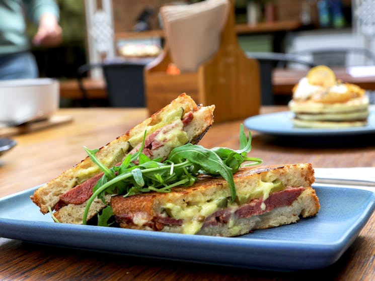 Corn beef toasted sandwich on sourdough with greens
