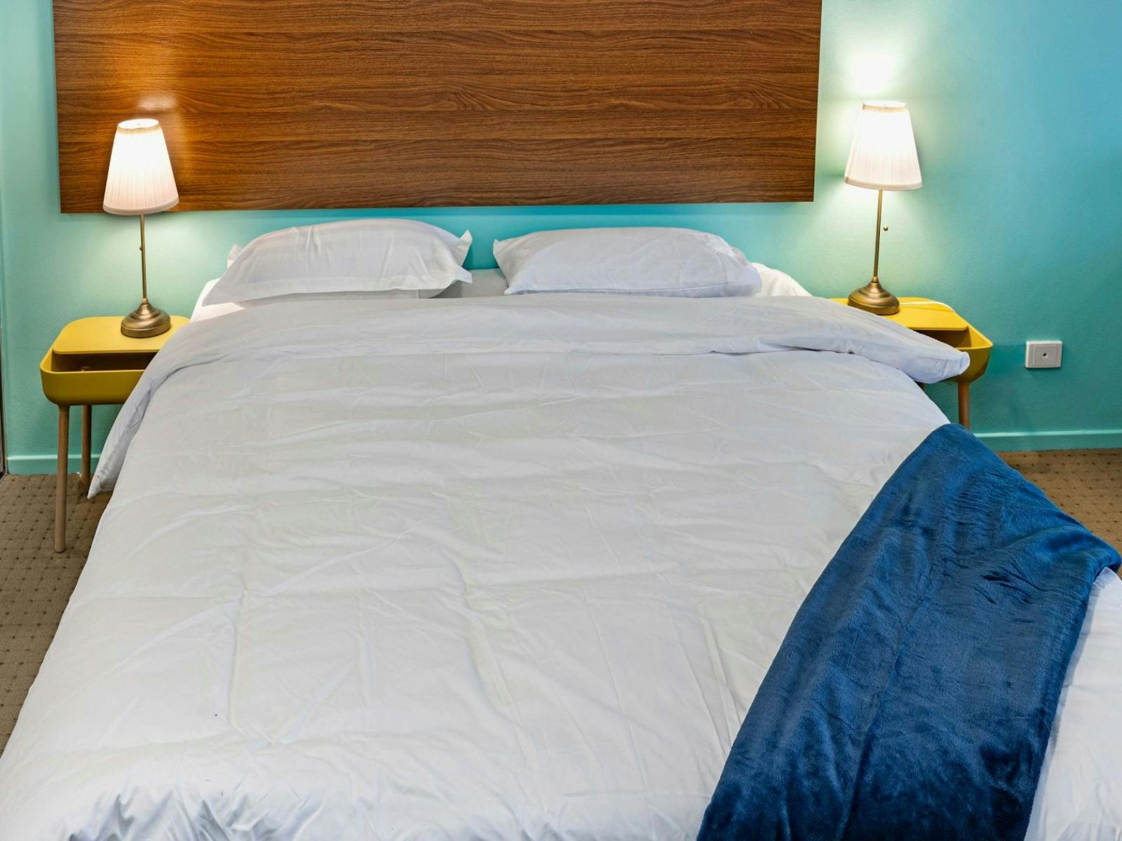 Bedroom featuring a comfortable king-size bed & wooden headboard