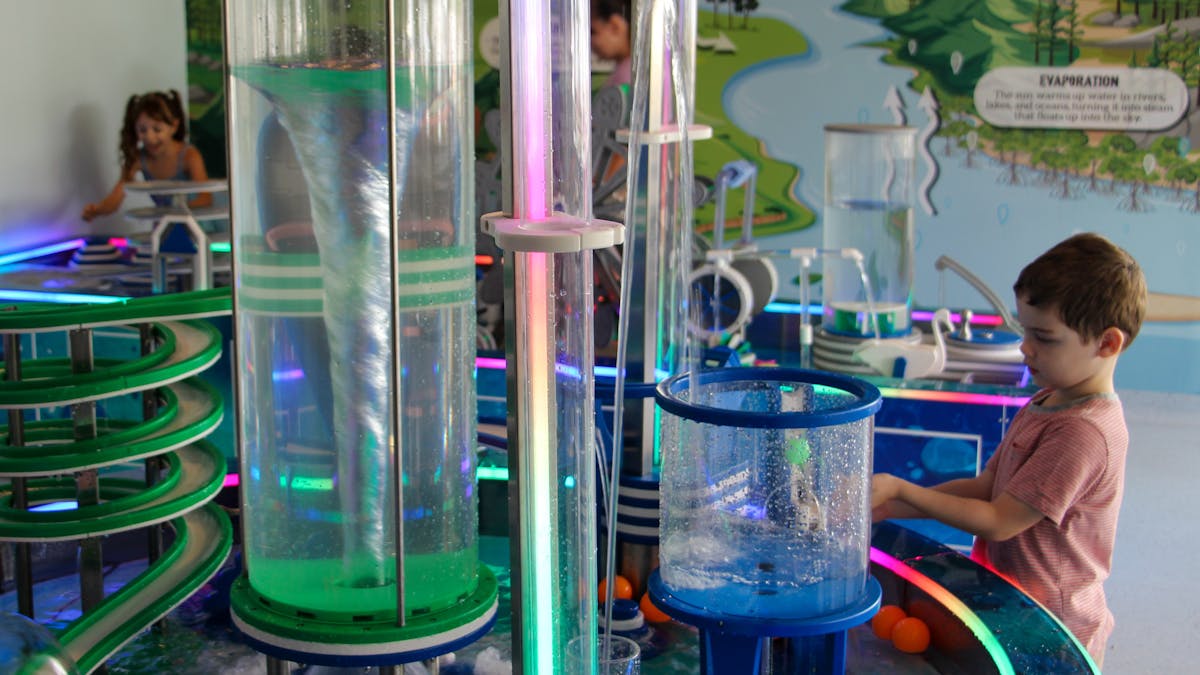 Two children playing with the movement of water in the Water Science Zone.
