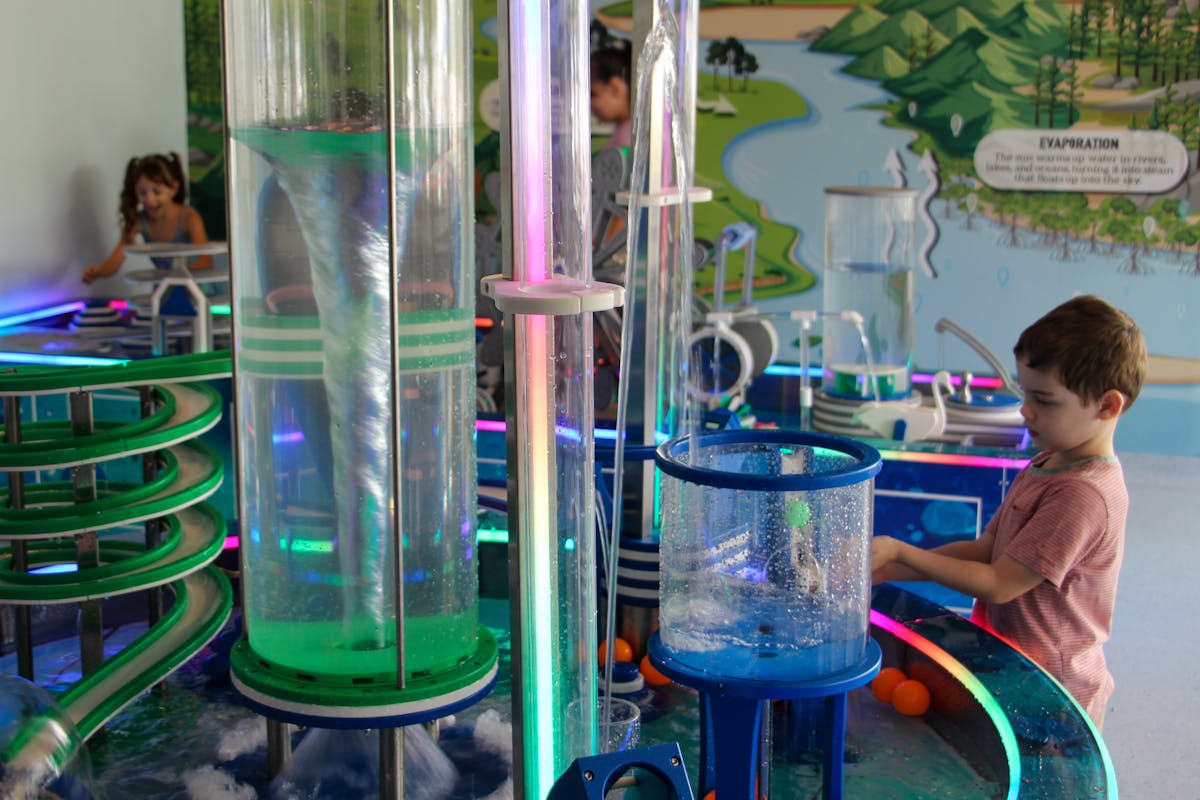 Two children playing with the movement of water in the Water Science Zone.