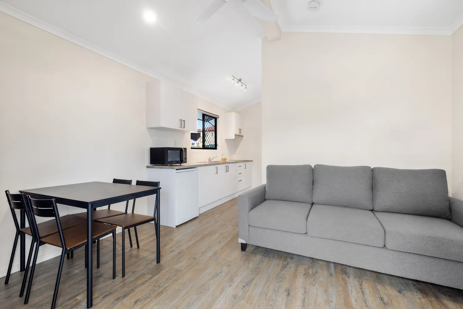 Two Bedroom lounge room with dining table, tv and kitchenette.