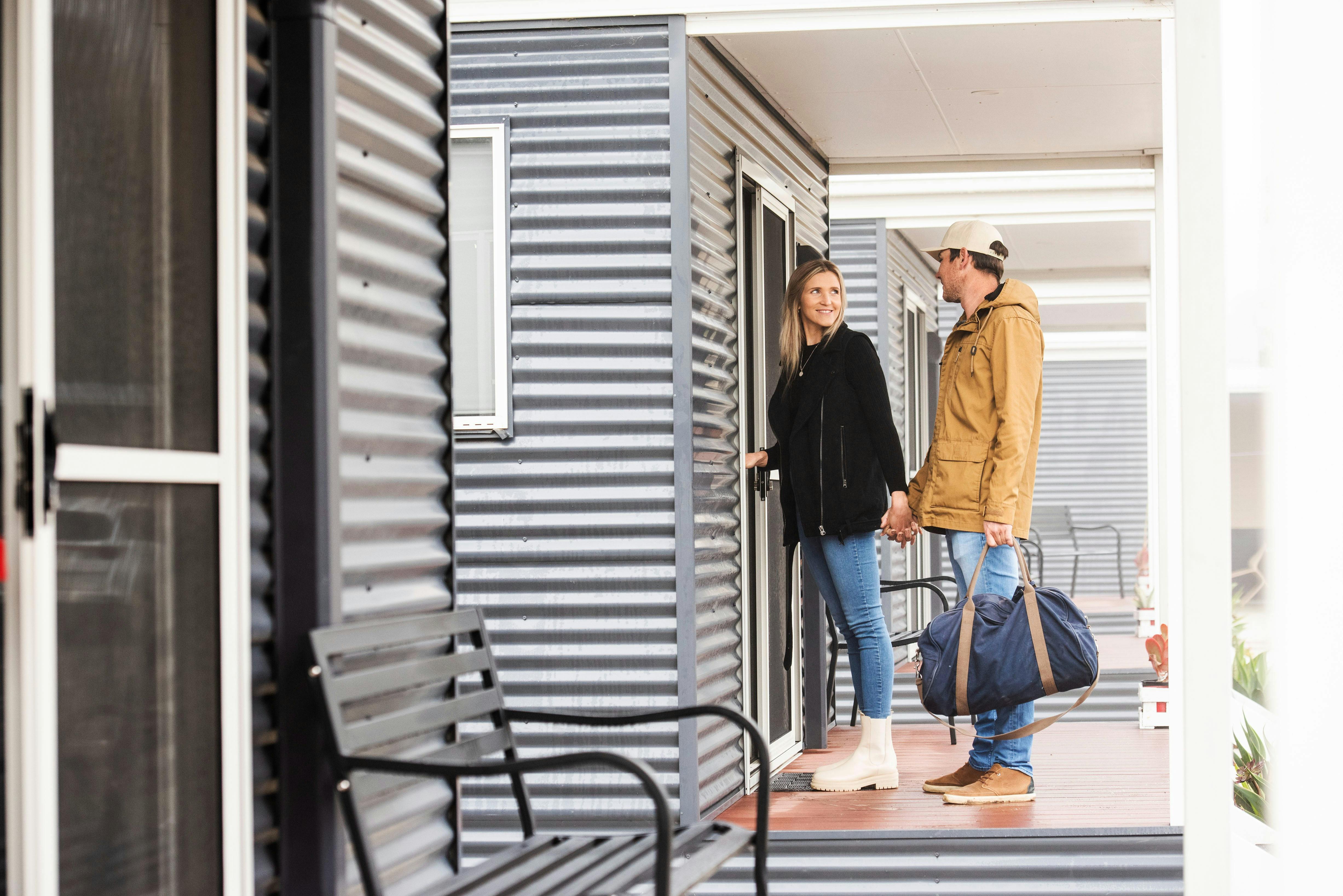 Woman in hand with man entering cabin accommodation.