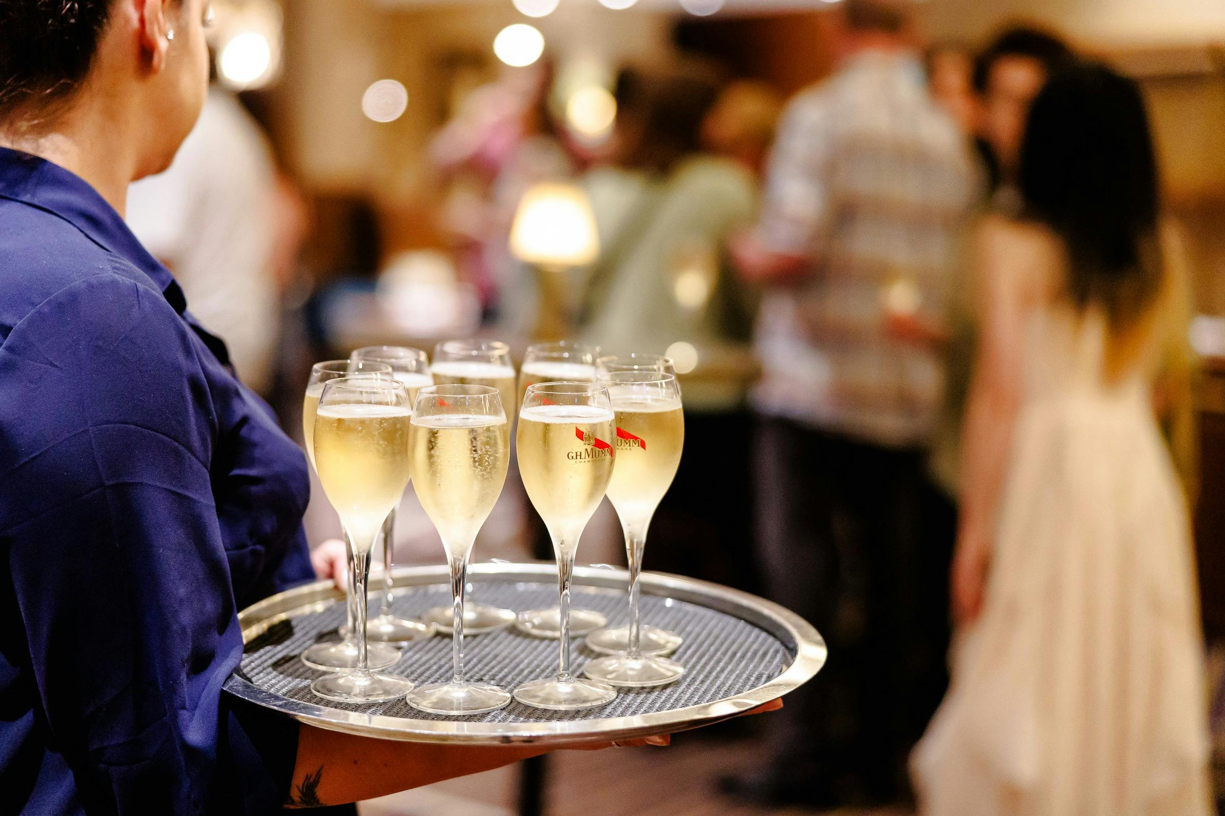 Staff member serving glasses of sparkling wine to guests at Rydges South Bank Brisbane