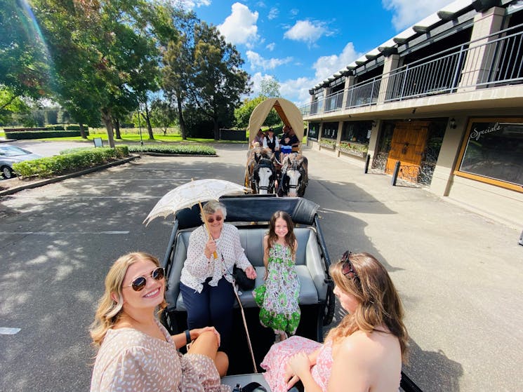 People enjoying a wine tour by horse and carriage