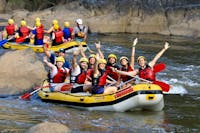 Group of 7 plus guide wave to camera from their raft on the Barron Gorge National Park River