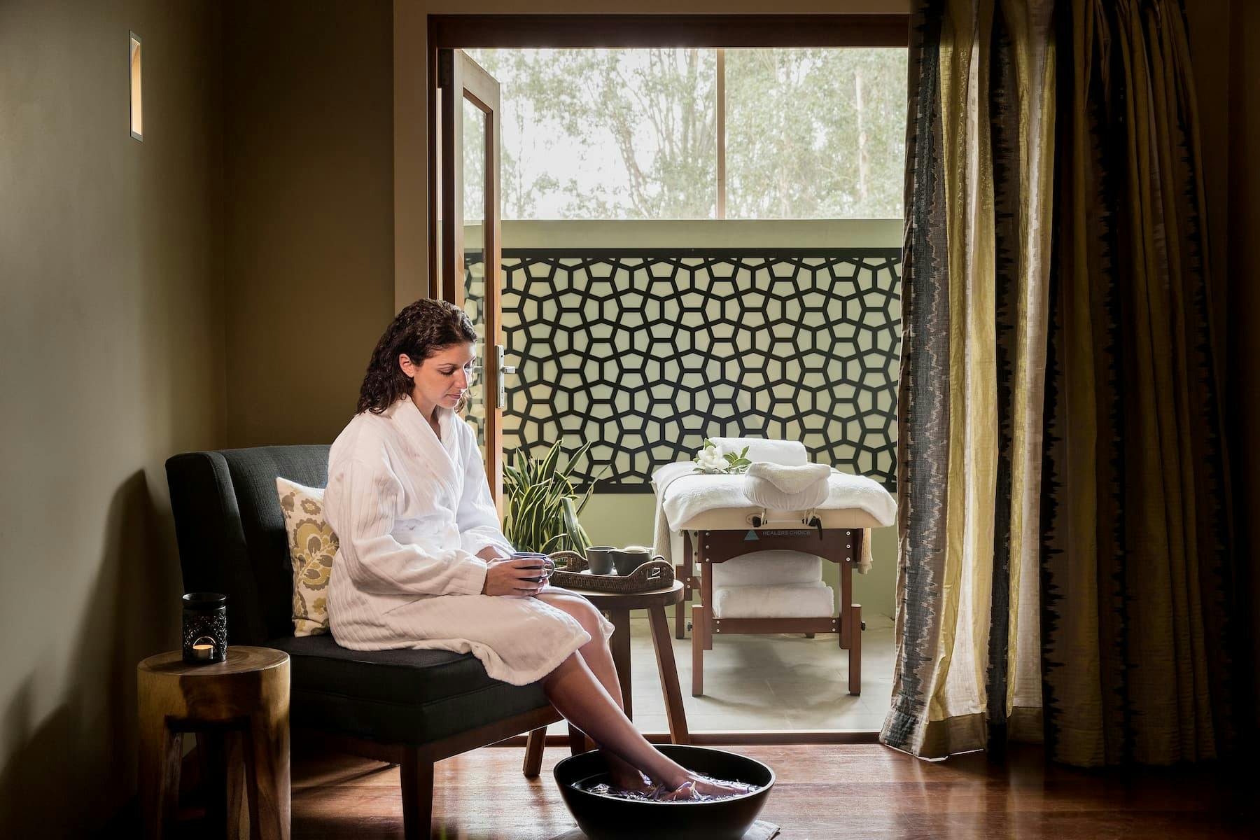 A woman in a robe sitting in a treatment room at Spa Anise
