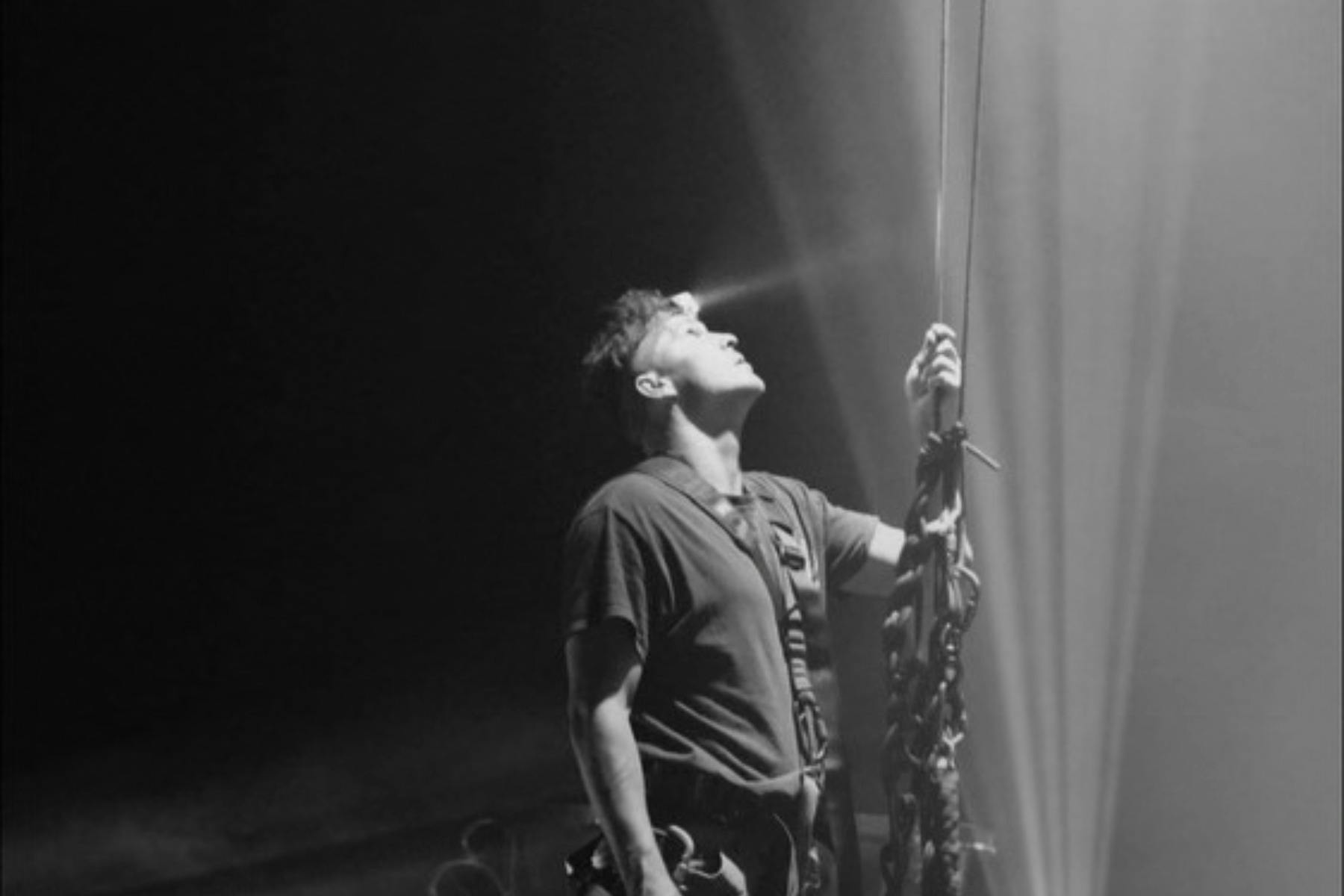 Man holding rigging rope looking up