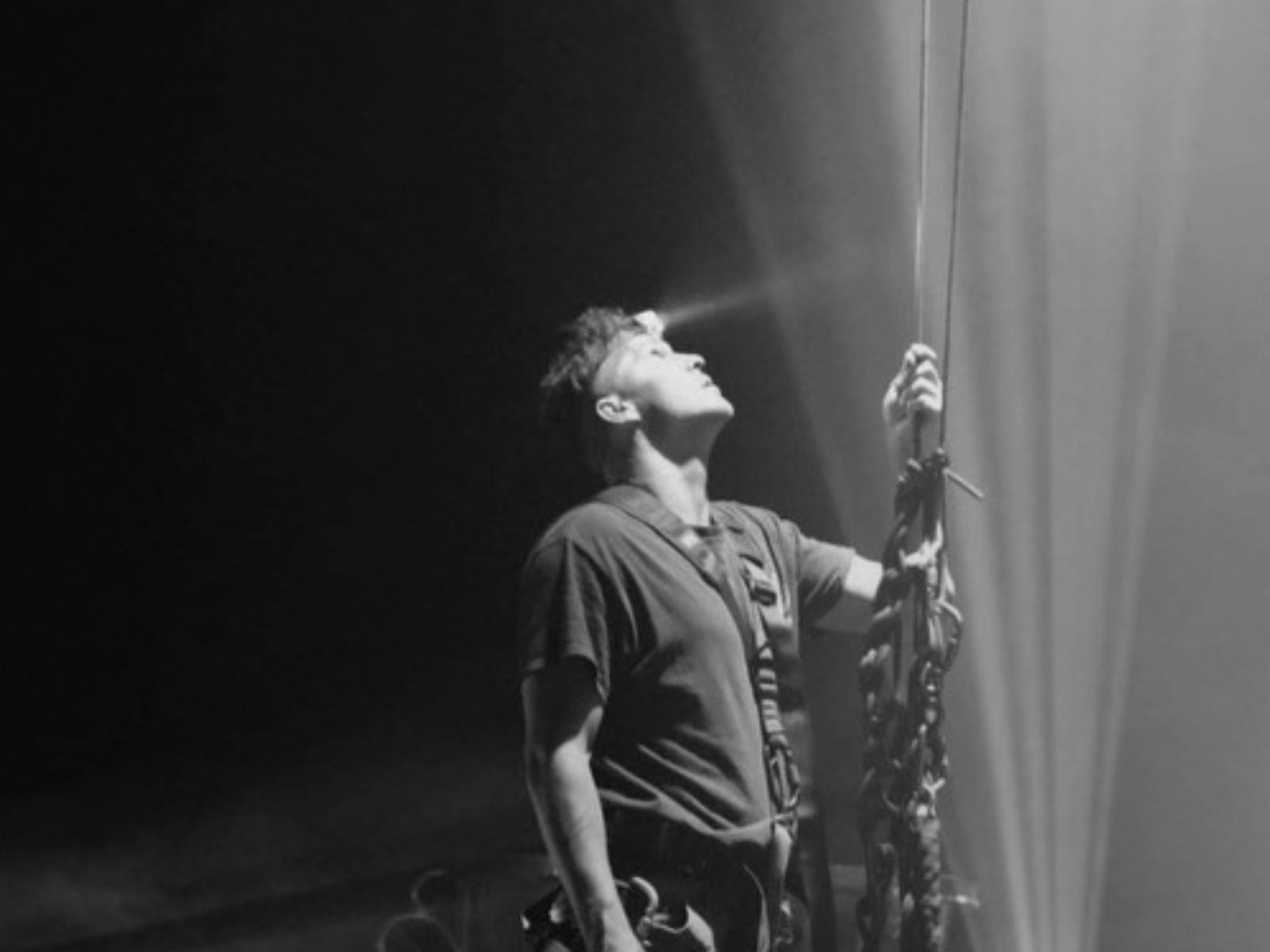 Man holding rigging rope looking up