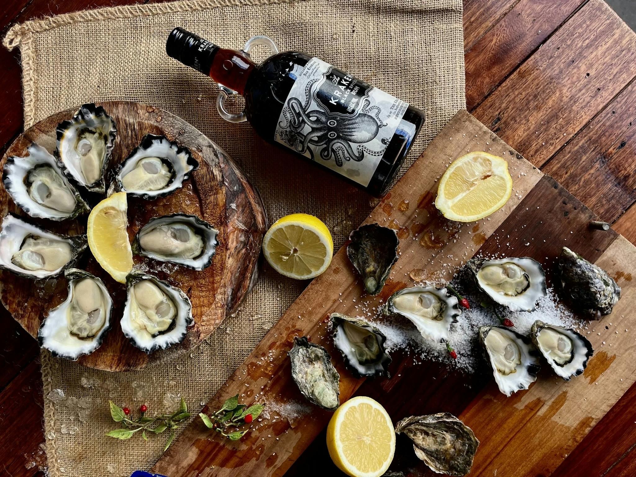 A top down shot of a spread of oysters, lemon and other garnishes