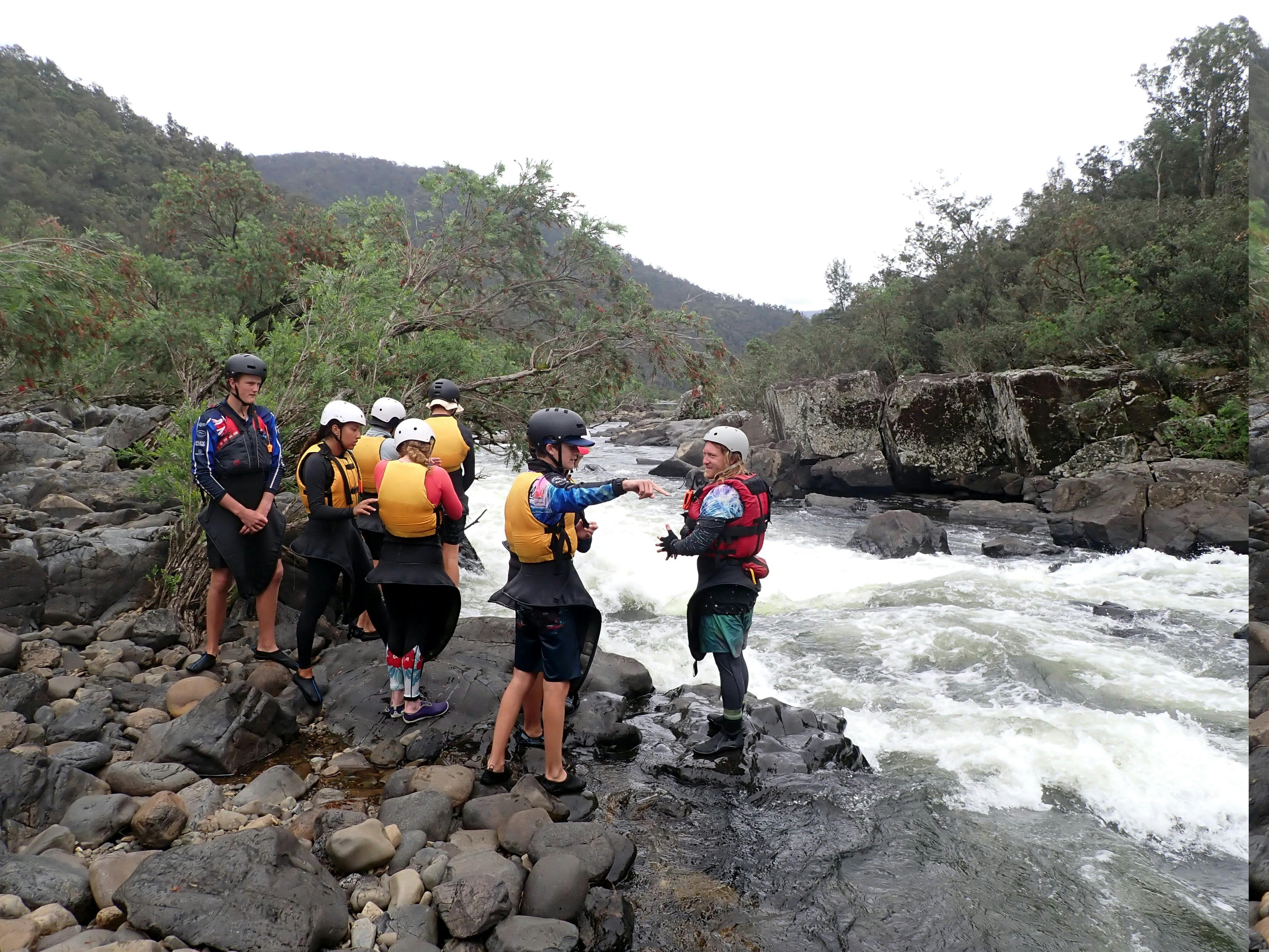 A group of Nymboida River Kayak Adventurerers are standing beside a rapid looking for the best line