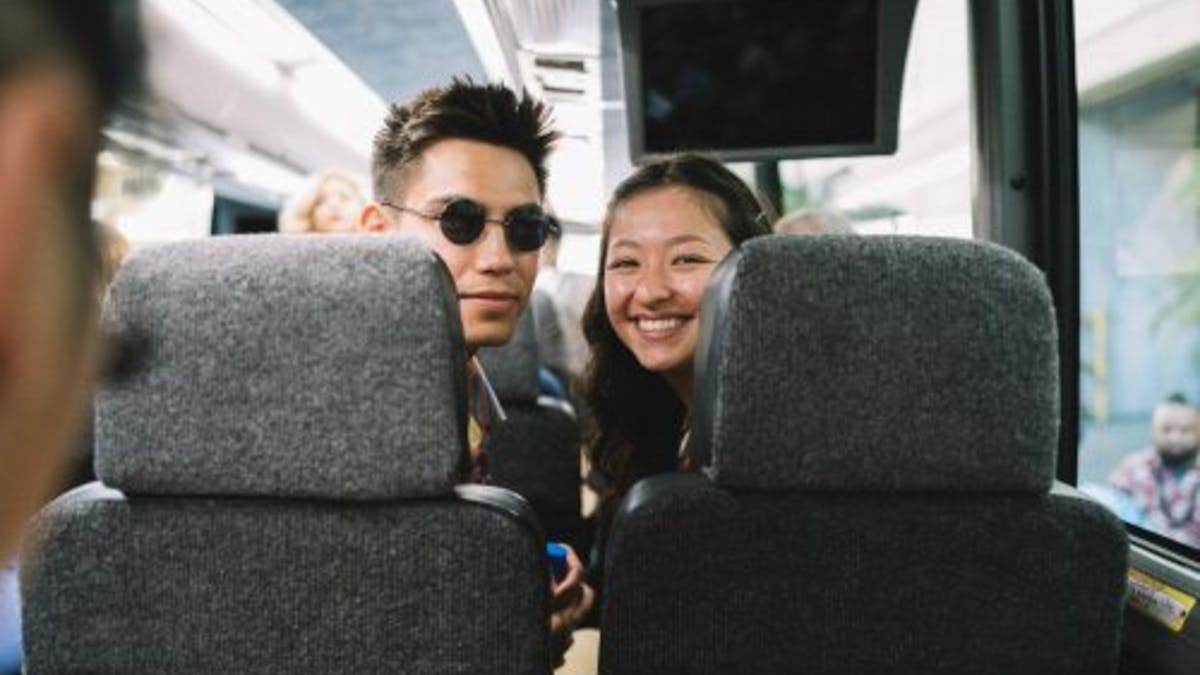 two people in a bus looking behind them at the camera