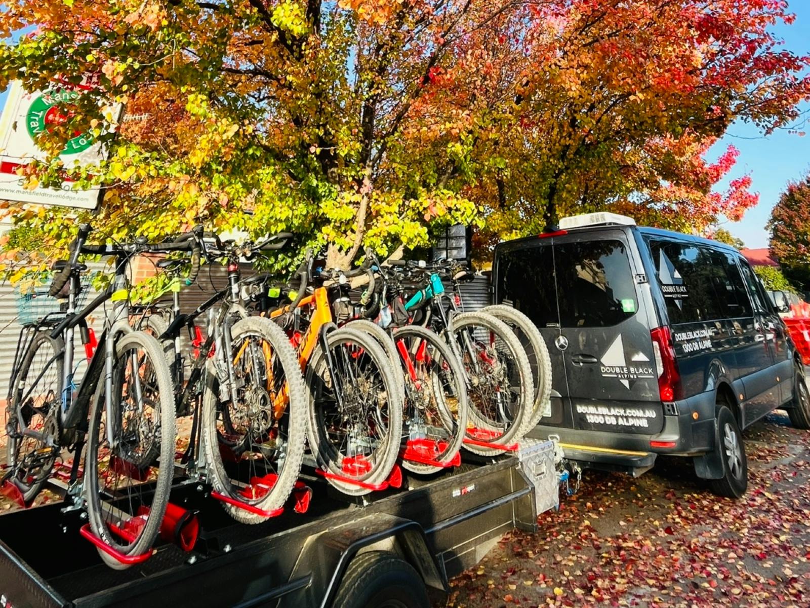 Double Black Alpine shuttle with bike trailer surrounded by trees displaying Autumn colours