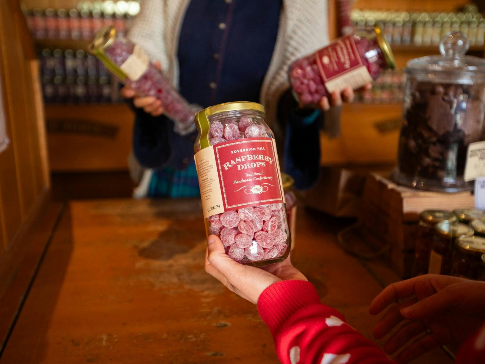 Hand holding jar of Raspberry Drops