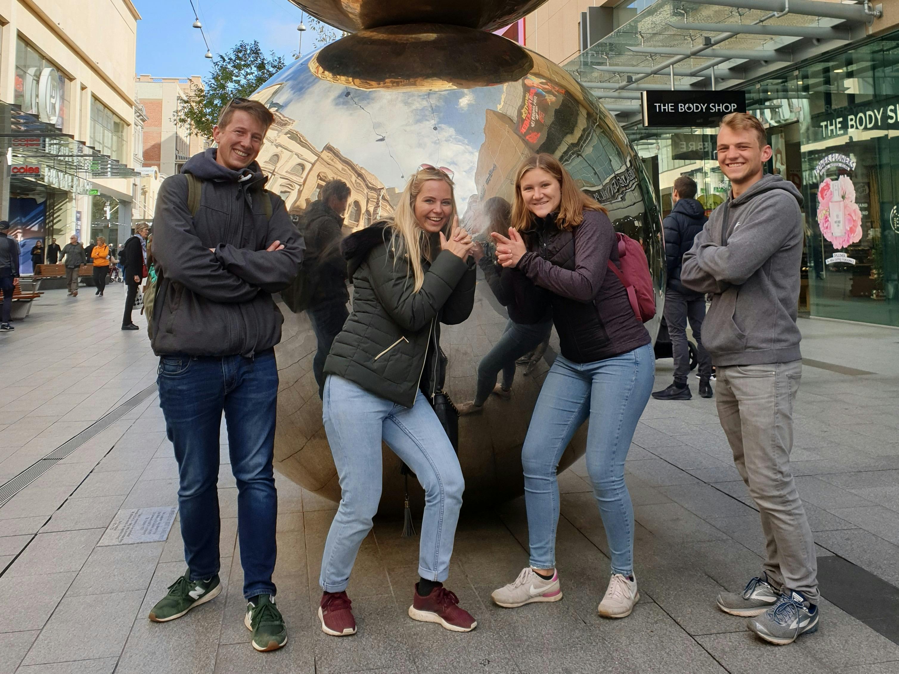 Four travellers pose in front of the Malls Balls sculpture in Adelaide's Rundle Mall while on tour.