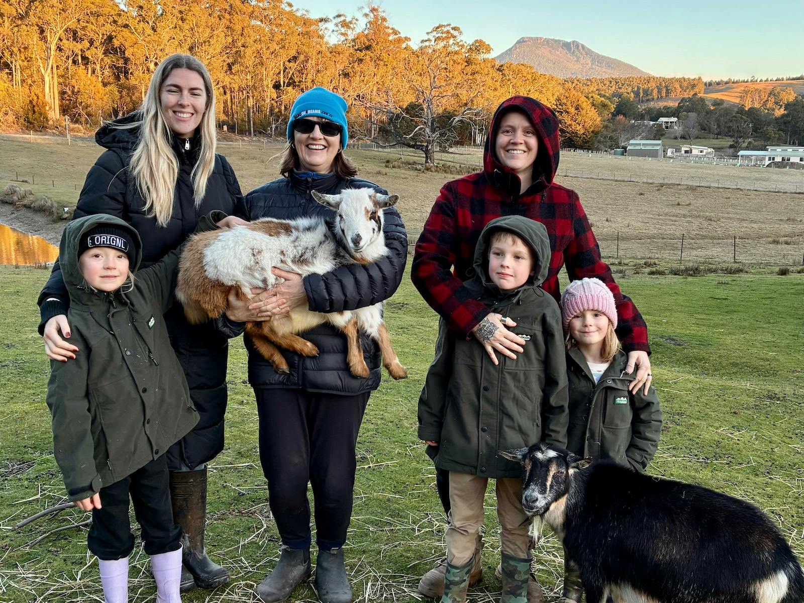 Family holding a baby goat