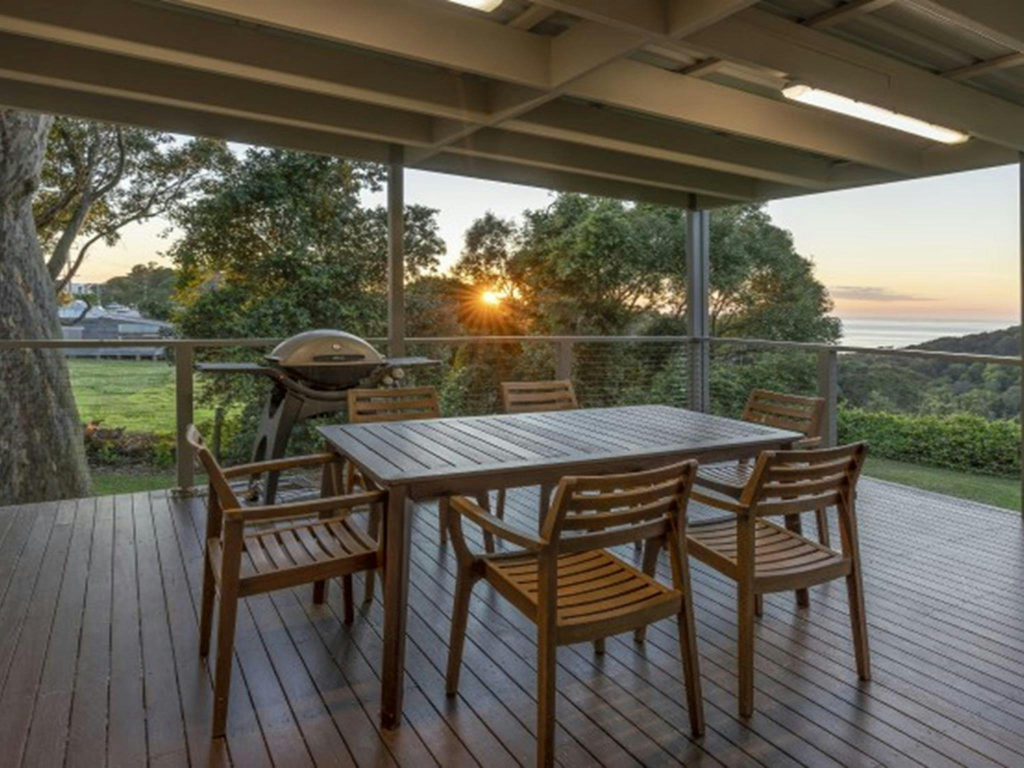 The deck of Baileys Cottage with table and chairs in Glenrock State Conservation Area. Photo: john