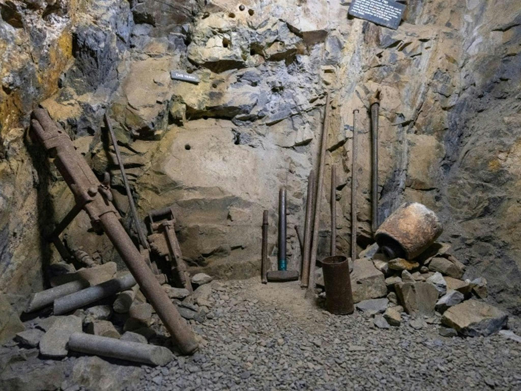 历史悠久的采矿工具矗立在鲍德山旅游矿井崎岖的岩壁前。照片：约翰